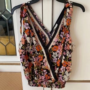 Floral V neck sleeveless top with elastic waist band.  Size Medium
